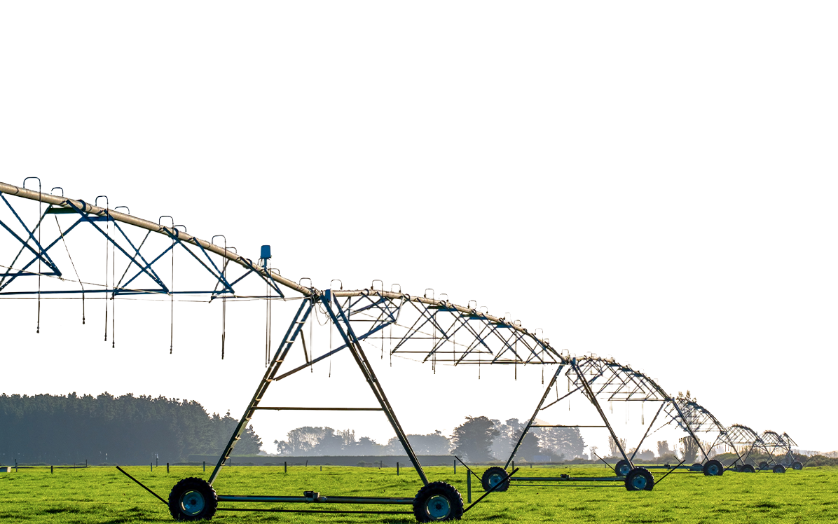 Center pivot irrigation spans on wheeled towers in a green pasture